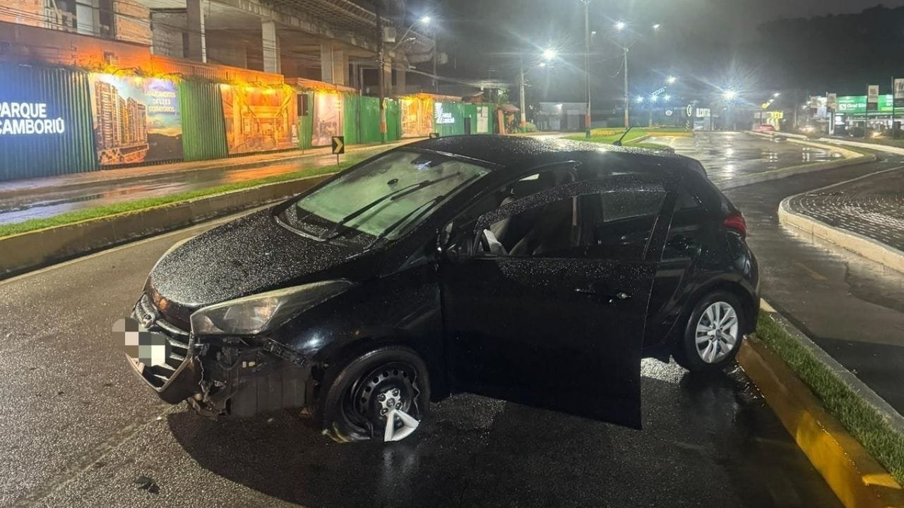 acidente de trânsito Camboriú,motorista embriagado,Avenida Santa Catarina,HB20 colidido,bafômetro recusado,embriaguez ao volante,licenciamento vencido,polícia militar SC,uso de algemas,resistência à prisão,Instituto Geral de Perícias,delegado Camboriú,garrafa de cerveja no carro,voz de prisão motorista,carro removido ao pátio